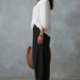 Conjunto con top blanco de hombros descubiertos y pantalones anchos